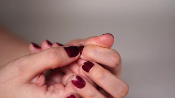 Nervous Woman Picks at Her Red Nails