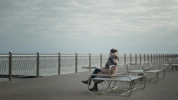 Woman Reading A Book On Seashore