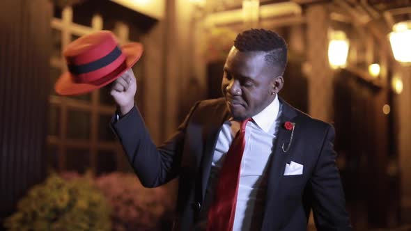 African Businessman Dancing with Hat in the Night City