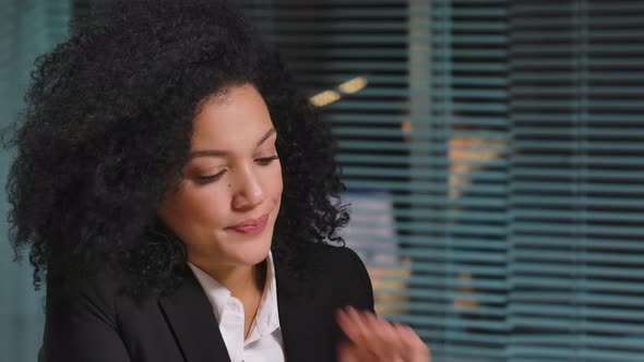 Portrait of African American Woman Texting with Client Using Laptop and Rejoices at Good Deal