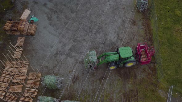 Harvested and wrapped spruce trees moved by tractor on farm; aerial