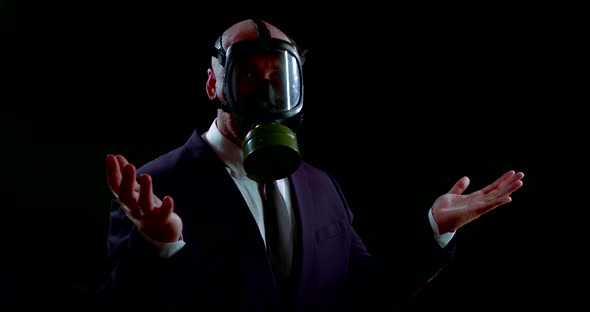 a Man in a Business Suit Stands in the Dark with a Gas Mask on His Head During Environmental