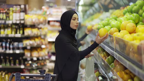 Muslim Women Shopping for Groceries Taking Fruits From the Shelf