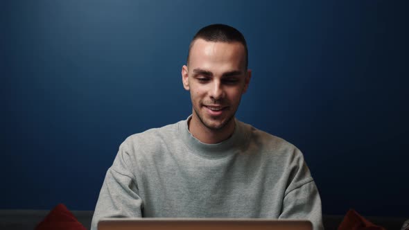 Smiling Caucasian Man Uses a Laptop at Home or Office. Excited Professional Reading Good News. Happy