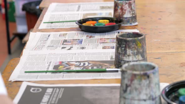 Art Teacher Setting Out Painting Equipment Ready For Students Class