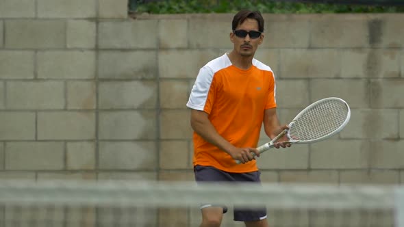 Two men playing outdoor tennis together.