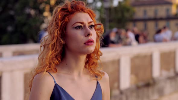 thoughtful red-haired woman on Lungotevere looking away thinking