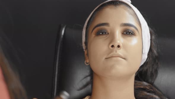 Close up of make up artist putting a powder on woman's neck and doing the make up