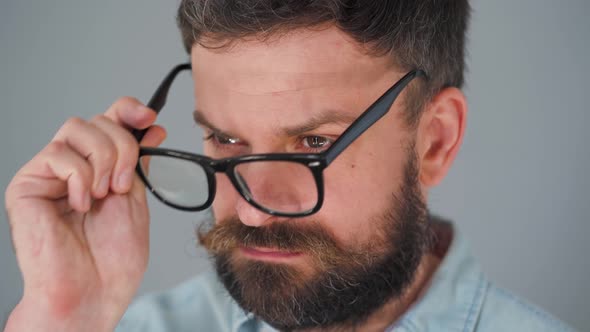 Portrait of a Handsome Bearded Puts on Glasses