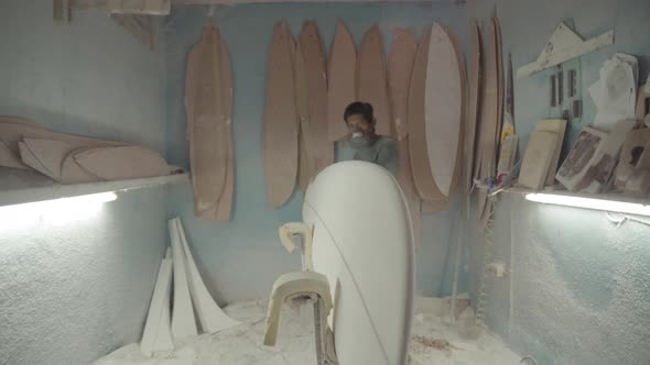 Artisan Sanding Edges of Surfboard