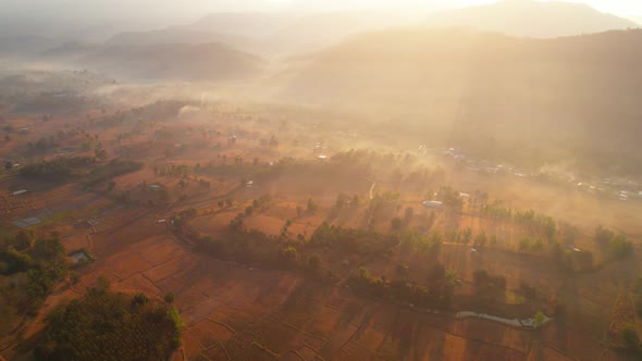 Aerial view from a drone over misty landscape on farmland. 4K