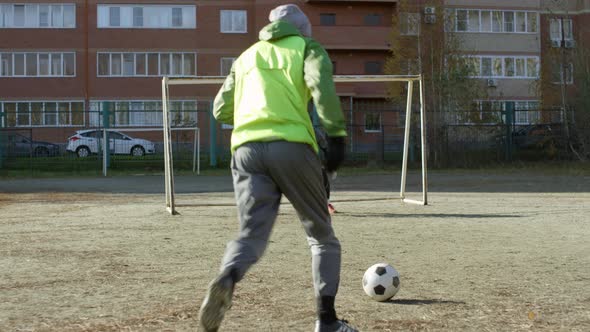 Goalkeeper Catching Soccer Ball while Training on Outdoor Field