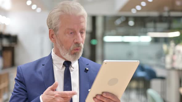 Senior Old Businessman Doing Video Chat on Tablet 