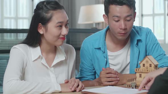 Close Up Of Asian Couple Listens To A Real Estate Agent Explaining About The House Purchase Contract