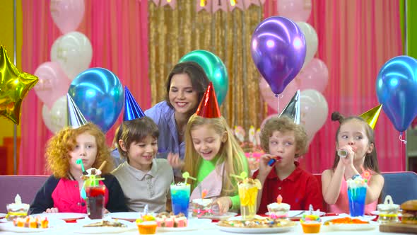 Kids in Colorful Hats Celebrating Birthday with Mother and Fiends