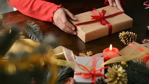 Young woman preparing gift box for Christmas