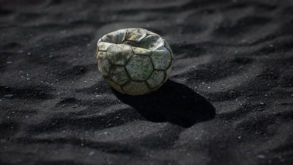 Old Football Ball on the Black Sand