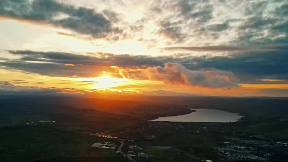 Aerial drone view of Moldova at sunset. Panorama view of hills, greenery, lake, clouds