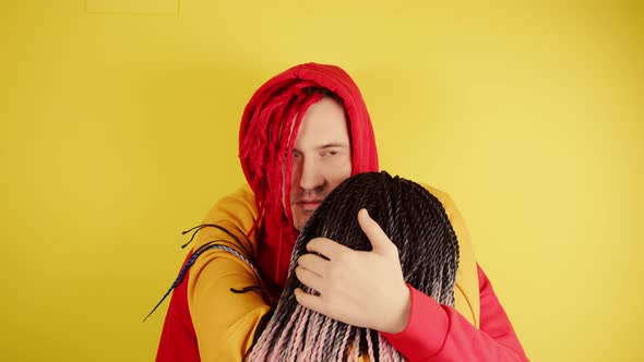 Young Man with Red Dreadlocks in Hood Hugs Unrecognizable Woman