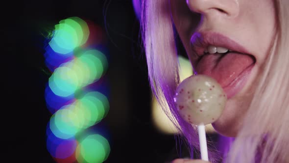 Blonde Sexy Woman Licking a Lollipop