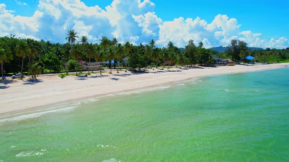 Drone flying at the tropical white beach with coconut trees