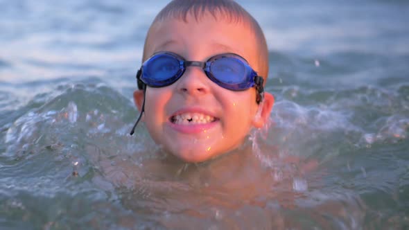 Cheerful boy in goggles bathing in the sea