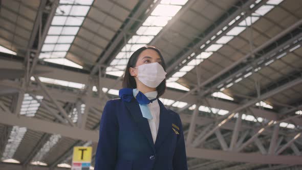 Cabin crew or air hostess wear face mask walking in airport terminal to the airplanel during Covid19