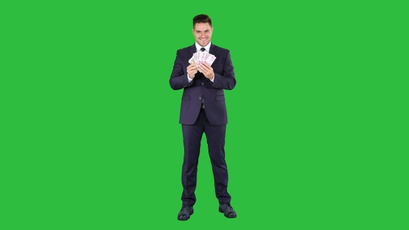 Business man showing euro banknotes smiling on a Green