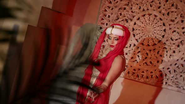 a Woman in a Turban a Red Scarf and a Sequined Dress Dances in the Sunset Light