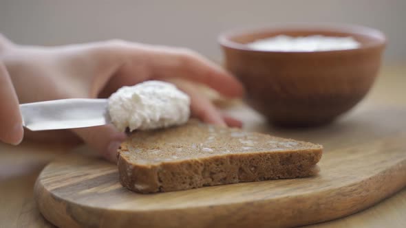 Spreading Curd Cheese on a Piece of Bread