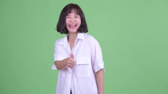 Happy Beautiful Asian Businesswoman Giving Thumbs Up