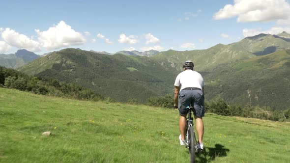 Young Man Ride Along By Mountain Bike in Outdoor Nature Mountain Scenery in Summer Day Gimbal
