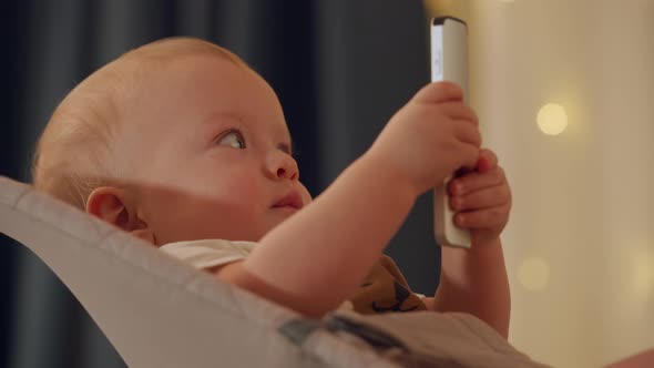 Cute Kid Holding Remote Control for TV Digital Media Player and Watching TV