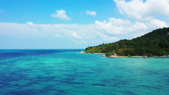 Aerial top down landscape of idyllic resort beach vacation by blue water with white sandy background