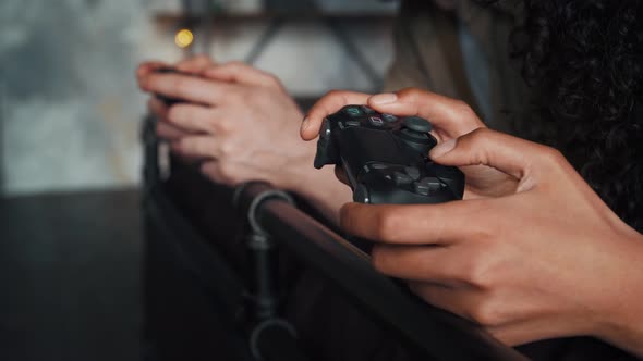 Hands of Interracial Couple are Holding Wireless Controllers and Playing Video Game on Console