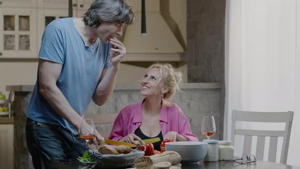 Happy active family couple preparing food and laugh at home