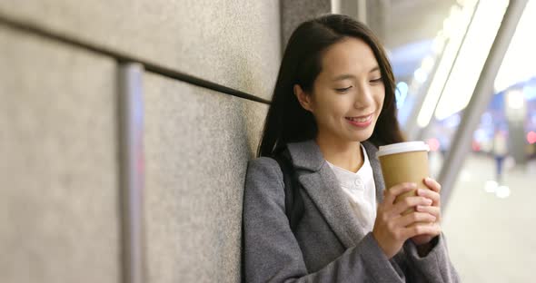 Woman feeling cold outside hold with hot coffee cup in city