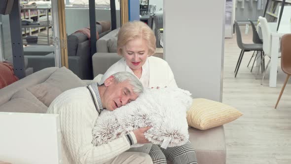 Lovely Senior Couple Choosing New Cushions at Furniture Store