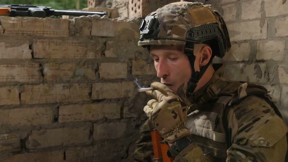 Tired Army Soldier Relieving Stress with Cigarette alt