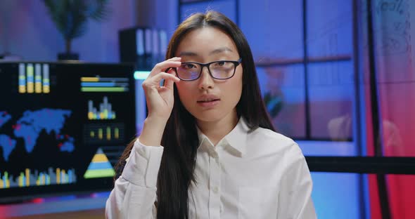 Asian Female Office Worker in Glasses Looking Into Camera with Friendly Face