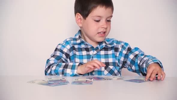 A 4Yearold Boy Counts Money Holds Euros in His Hands
