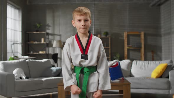 Portrait of a Taekwondo Boy at Home Looks Into the Camera