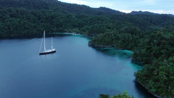 Aerial View Of Triton Bay: Boat On Turquoise Sea And Green Tropical Trees In Kaimana Islands