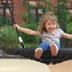 Little Girl Swing on Swing Looks at Camera Laughs and Smiles on Background on Playground - VideoHive Item for Sale
