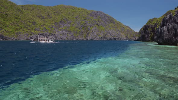 Tourist Island Hopping Boat in Ocean Strait with Rippled Surface. Matinloc Island. Tour C. Bacuit