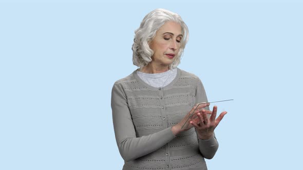 Mature Woman Using Glass Digital Tablet.