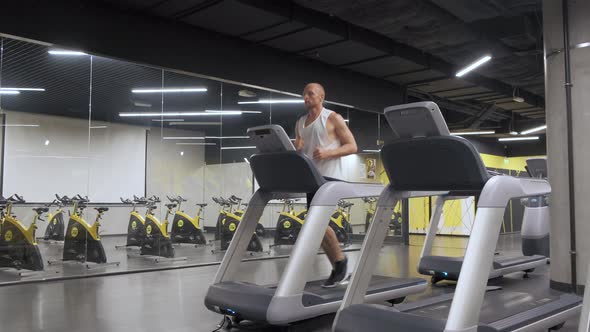 Young European Man Running on a Treadmill, doing Exercises in the Gym Slow-Motion Frame