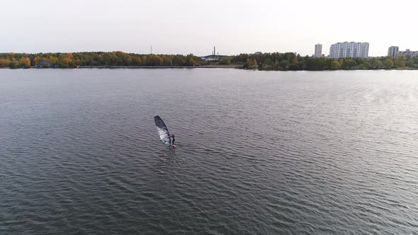 Aerial drone shot of alone windsurfer at big city pond