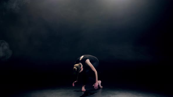 Pretty Young Woman Dancing in Dark Studio