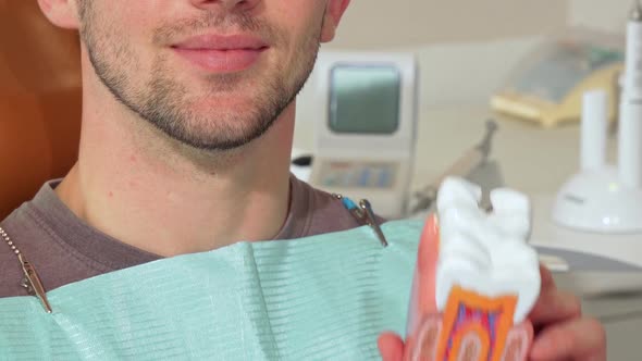 Man with White Healthy Teeth Smiling, Holding Dental Mold at the Clinic